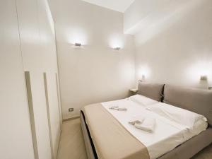レヴァントにあるAppartamento Kikoの白いベッドルーム(ベッド1台、タオル2枚付)