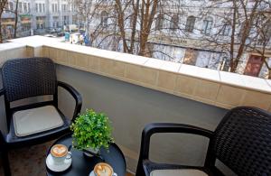 a balcony with two chairs and a table with two candles at Apartment & Parking "Opera at the corner" in Odesa