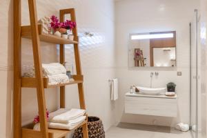 a bathroom with a sink and a shelf with towels at Hiddenbay Teos Hotel in Seferihisar