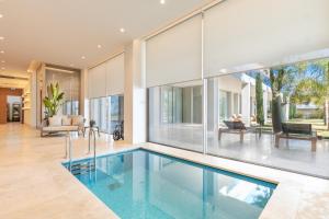 an indoor swimming pool in a house with glass walls at Hiddenbay Teos Hotel in Seferihisar