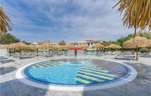 a fountain in a pool with chairs and umbrellas at Summertime in Bibione