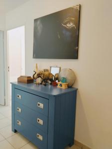 a blue dresser in a room with a painting on the wall at Au cœur du grand Lyon à côté de la gare Part-Dieu in Villeurbanne