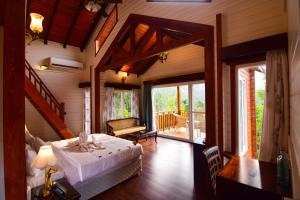 a bedroom with a bed in a room with a balcony at River Mist Resort in Mudigere