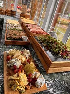 a buffet of different types of food on wooden boards at Wiatraki Nature Resort in Olsztynek