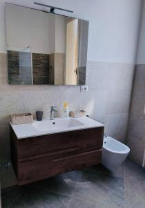 a bathroom with a sink and a mirror and a toilet at Villa fronte mare in Levanto