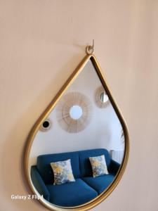 a mirror with a blue couch in a room at Charmant studio vue mer / parking / plage à 200m in Bastia