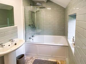 een badkamer met een bad en een wastafel bij Holme Cottage in Embsay