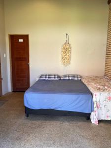 a bedroom with a bed and a chandelier at Bungalows Morro Do Chapeu Taiba in Taíba