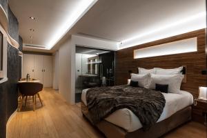 a bedroom with a large bed and a bathroom at Hôtel Origines par Adrien Descouls in Issoire