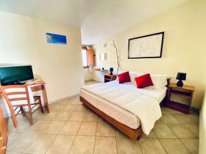 een slaapkamer met een bed en een bureau met een computer bij Hotel Velasole in Posada