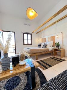 カリムノスにあるSpongia Apartments Kalymnosのベッドルーム1室(ベッド1台、木製テーブル付)