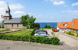 a church with cars parked in a parking lot at 1 Bedroom Awesome Apartment In Gudhjem in Gudhjem