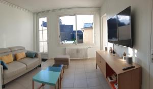 uma sala de estar com um sofá e uma mesa em Maison de ville située à 8 kms du Mont St Michel em Pontorson