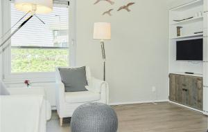 a white living room with a chair and a tv at Vrije Vogels in Bergen aan Zee