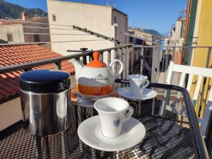 a tea pot and cups on a table on a balcony at MOLO 78 Case Vacanze in Cefalù