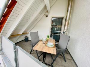 a table and chairs on the back porch of a house at Ferienwohnung Barner - KEINE MONTEURE in Owen