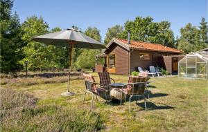 a table and chairs under an umbrella in a yard at Awesome Home In Højby With Wifi in Højby