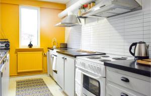 eine Küche mit weißen Geräten und einer gelben Wand in der Unterkunft Nice Home In Orrefors With Jacuzzi in Orrefors