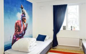 a bedroom with a painting of a man with a lighthouse at Nice Home In Orrefors With Jacuzzi in Orrefors