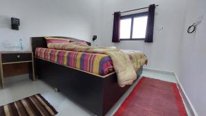 a bedroom with a bed with a window and a rug at JiNo Homestay in Khajurāho