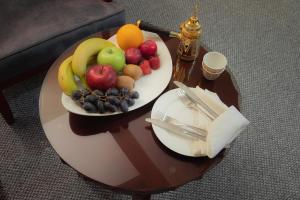a table with a plate of fruit on it at Amman Inn Boutique Hotel in Amman