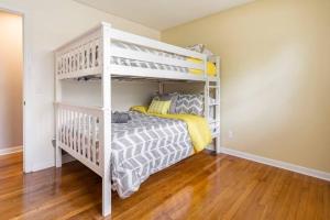 a white bunk bed in a room with wooden floors at Updated home near Fort Jackson in Columbia