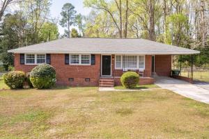 a red brick house with a porch and a driveway at Updated home near Fort Jackson in Columbia