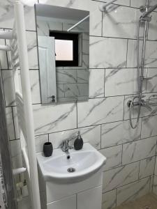 a white bathroom with a sink and a mirror at CAZARE JASMINA in Corbu +78 photos