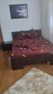 a bed sitting in a room with a bedspread with leaves at Apartament Ema in Mangalia