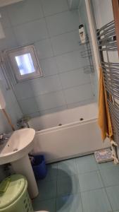 a bathroom with a bath tub and a sink and a toilet at Apartament Ema in Mangalia