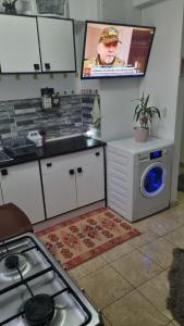 a kitchen with a stove and a washing machine at Apartament Ema in Mangalia