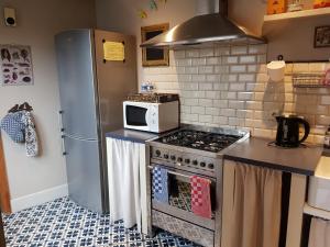 a kitchen with a stove and a microwave at Ypres Ramparts House in Ypres