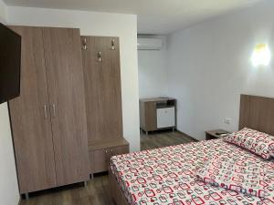 a bedroom with a bed and a dresser in it at CAZARE JASMINA in Corbu