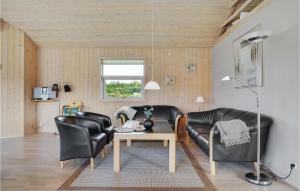 salon z 2 skórzanymi krzesłami i stołem w obiekcie Nice Home In Hovborg With Sauna w mieście Hovborg