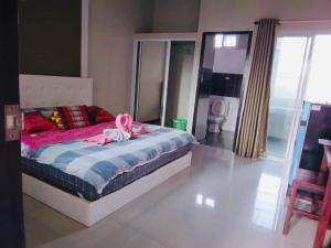 Preme Apartment @maejo في Ban Pa Lan: غرفة نوم بسرير عليها شريط وردي