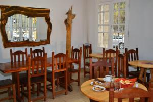 een restaurant met houten tafels en stoelen en een spiegel bij La Salamanca in Salta