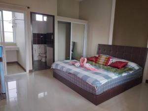 um quarto com uma cama com toalhas cor-de-rosa em Preme Apartment @maejo em Ban Pa Lan