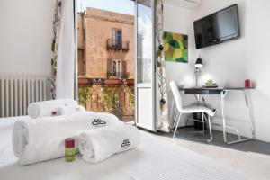 um quarto de hotel com uma cama com toalhas em White em Palermo