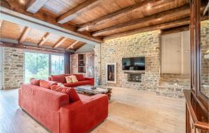 a living room with red furniture and a stone wall at Stunning Home In Castino With Wifi And 4 Bedrooms in Castino