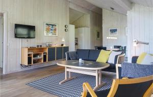 a living room with a couch and a table at Stunning Home In Aakirkeby With Wifi in Vester Sømarken