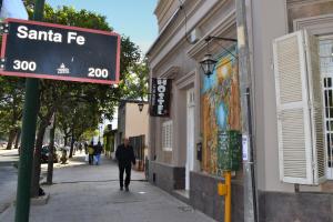 a man walking down a street next to a sign at La Salamanca in Salta