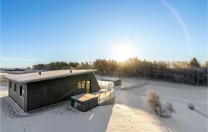 Lihme的住宿－Beautiful Home In Spttrup With Wifi，雪中的房子,太阳在后面
