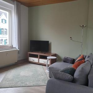 uma sala de estar com um sofá e uma televisão de ecrã plano em Das Düsselapartment em Haan