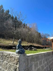 Eine Statue einer Frau, die an einer Wand sitzt. in der Unterkunft Villa Camino in Saparewa Banja