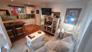 a living room with a couch and a kitchen at Crescent cottage in Knysna