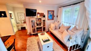 a living room with a couch and a tv at Crescent cottage in Knysna