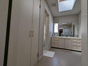 a large kitchen with white cabinets and a sink at 柳川ゲストハウス 憩 (IKOI) in Yanagawa
