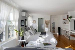 Dormitorio blanco con cama y mesa en Travellers Retreat Bayview en Bay View