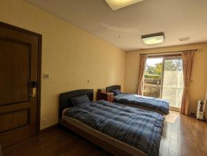 柳川的住宿－柳川ゲストハウス 憩 (IKOI)，一间卧室设有两张床和窗户。