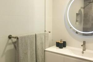 a white bathroom with a sink and a mirror at Travellers Retreat Bayview in Bay View